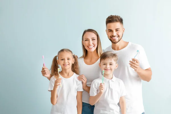 Retrato de familia con cepillos de dientes sobre fondo claro —  Fotos de Stock