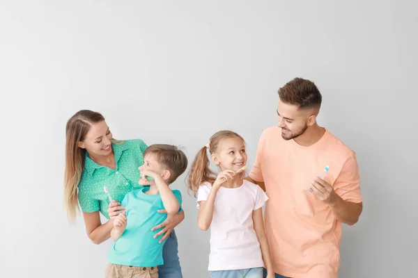 Porträtt av familj borsta tänderna på ljus bakgrund — Stockfoto