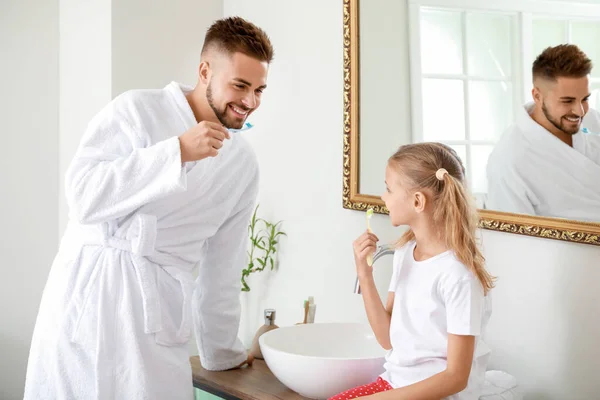 Vader en zijn dochtertje poetsen tanden in de badkamer — Stockfoto