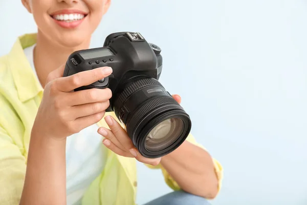 Vrouwelijke fotograaf op lichte achtergrond, close-up — Stockfoto
