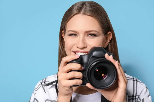 Beautiful female photographer on color background — Stock Photo, Image