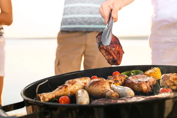 Homem cozinhar carne saborosa na churrasqueira ao ar livre, close-up — Fotografia de Stock