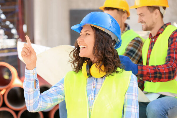 Portrait of female architect and her team in building area