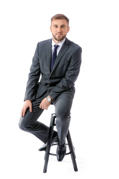 Portret van knappe zakenman zittend op stoel tegen witte achtergrond — Stockfoto