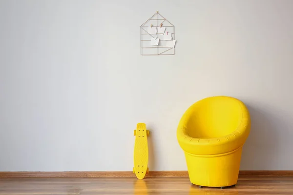Stilvoller Sessel mit Schlittschuhen nahe weißer Wand — Stockfoto