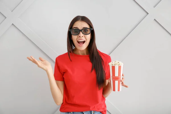 Surprised woman with popcorn on grey background — Stock Photo, Image