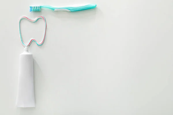 Пензлик, паста і намальований зуб на білому тлі — стокове фото