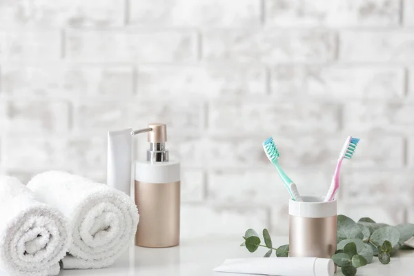 Зубные щетки с пастой, полотенцами и мылом на столе в ванной комнате — стоковое фото