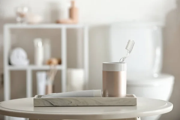 Cepillo de dientes con pasta en la mesa en el baño — Foto de Stock