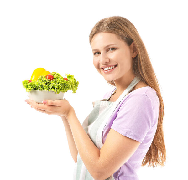 Beautiful young woman in apron and with vegetables on white background