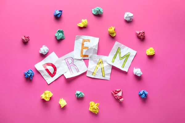 Folhas de papel formando palavra DREAM no fundo de cor — Fotografia de Stock