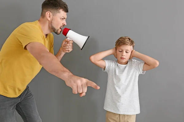 Το αγοράκι αγνοεί τον θυμωμένο πατέρα του με μεγάφωνο σε γκρι φόντο. — Φωτογραφία Αρχείου