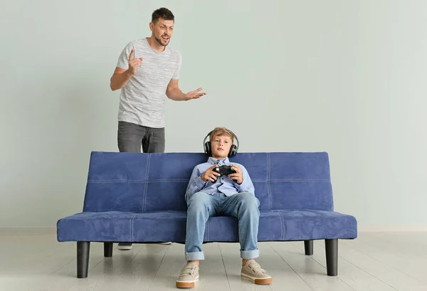 Menino jogando videogame e ignorando seu pai irritado em casa — Fotografia de Stock