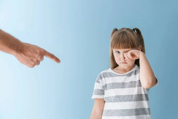 Enojado padre regañando a su pequeña hija llorando contra el fondo de color —  Fotos de Stock