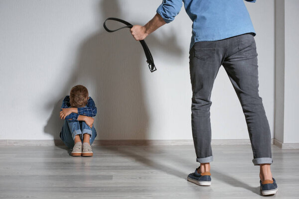 Man threatening his little son at home. Physical punishment concept