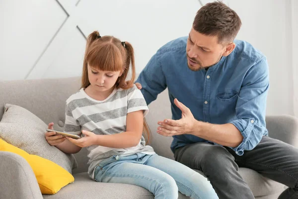 Menina com telefone celular ignorando seu pai irritado em casa — Fotografia de Stock