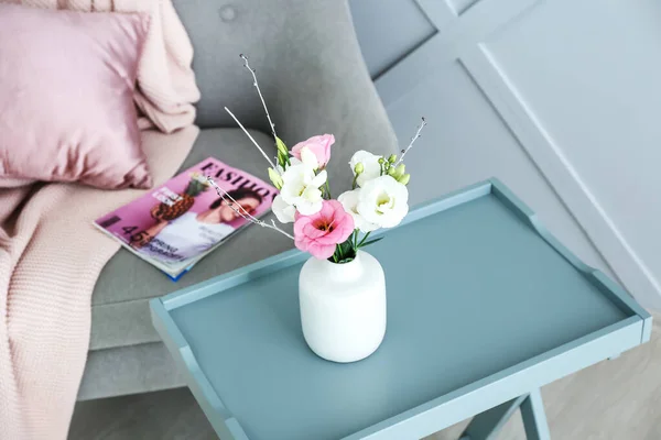 Váza s krásnými květinami na stole v místnosti — Stock fotografie