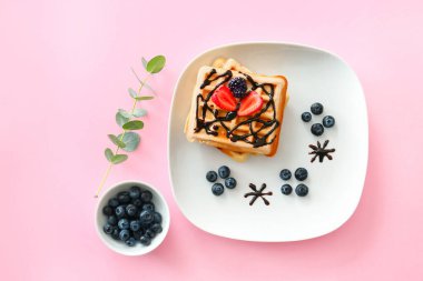 Tatlı waffle 'lı tabak ve renkli böğürtlen.