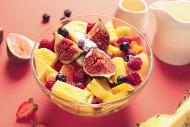 Renkli arkaplanda lezzetli meyve salatası ile kase