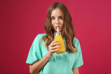 Arka planda portakal suyu olan güzel bir genç kadın.