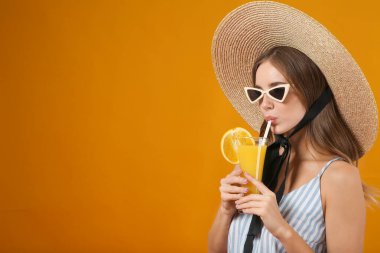 Arka planda portakal suyu olan güzel bir genç kadın.