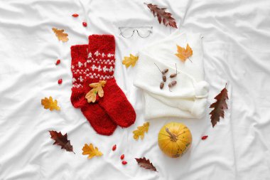 Beyaz kumaşta sonbahar havası için kıyafetlerle kompozisyon