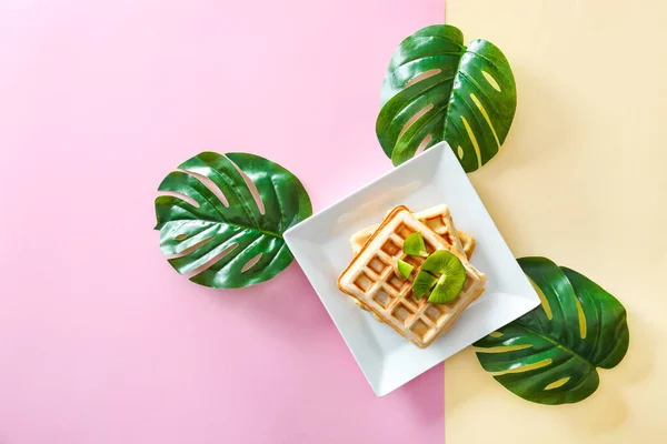 Plate with sweet tasty waffles on color background — Stock Photo, Image