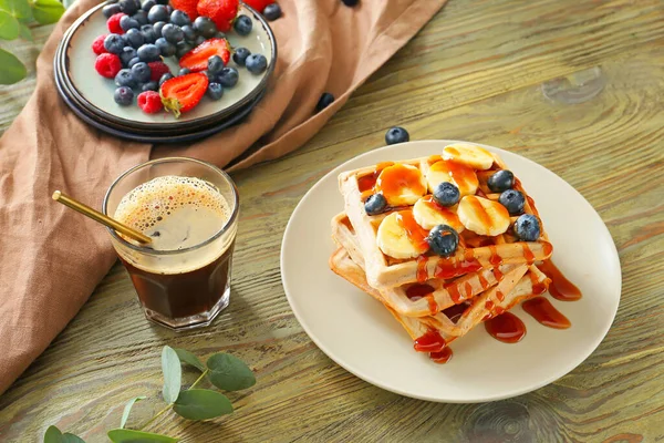 Bord met zoete lekkere wafels en koffie op tafel — Stockfoto