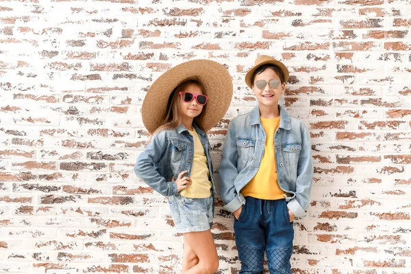 Bambini alla moda svegli contro muro di mattoni — Foto Stock
