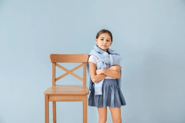 Roztomilé módní dívka s židlí na barevném pozadí — Stock fotografie