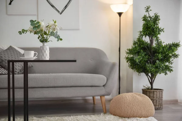 Vaso com decoração floral e xícara de café na mesa no quarto moderno — Fotografia de Stock