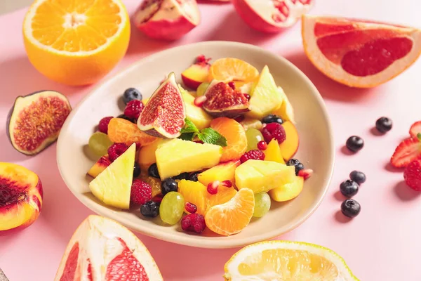 Plate ízletes gyümölcssaláta színes háttér — Stock Fotó