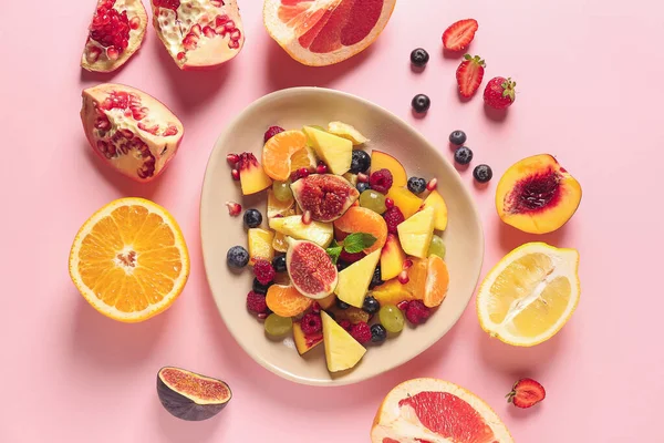 Placa con sabrosa ensalada de frutas sobre fondo de color —  Fotos de Stock