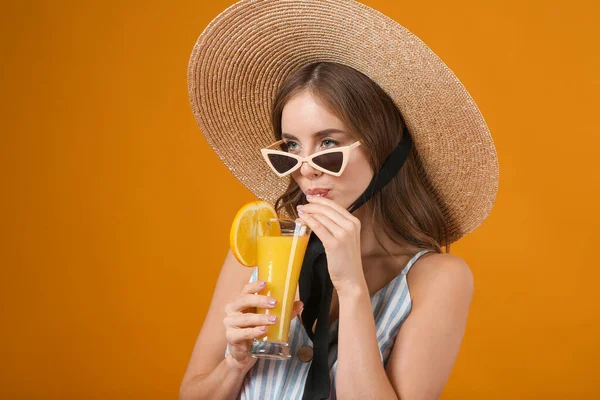 Beautiful young woman with orange juice on color background — Stock Photo, Image