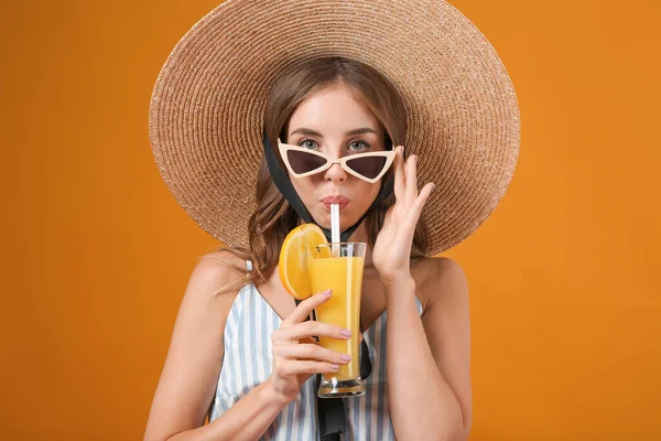 Beautiful young woman with orange juice on color background — Stock Photo, Image