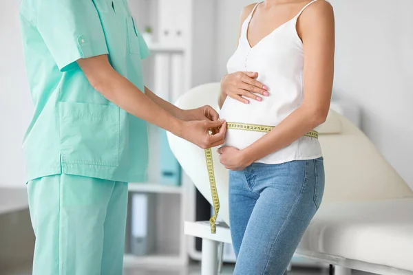 Gynécologue prenant des mesures du ventre de la femme en clinique — Photo