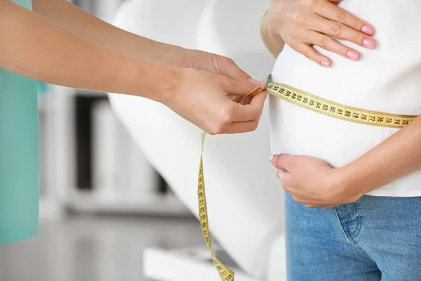 Ginecologista tomando medidas da barriga da mulher na clínica — Fotografia de Stock