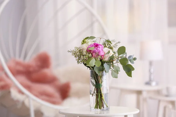 Vaso com buquê de flores bonitas na mesa no quarto — Fotografia de Stock