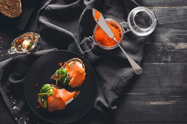 Lekkere sandwich met rode kaviaar op donkere tafel — Stockfoto