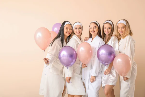 Beautiful young women in bathrobes and with air balloons on light background — ストック写真