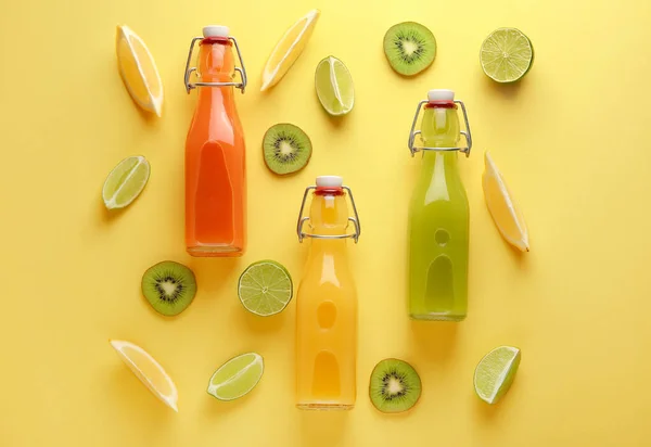 Μπουκάλια φρέσκου χυμού φρούτων σε φόντο χρώματος — Φωτογραφία Αρχείου