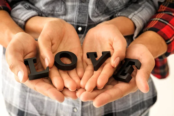 Couple with word LOVE composed from letters, closeup — Stock Photo, Image