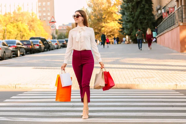 Gyönyörű fiatal nő bevásárló táskák átkelés az úton — Stock Fotó