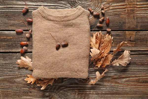 Hermosa composición otoñal con suéter y hojas sobre fondo de madera —  Fotos de Stock