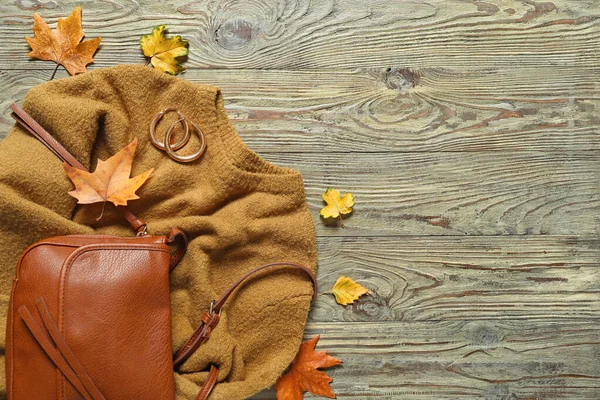Beautiful autumn composition with clothes and leaves on wooden background — Stock Photo, Image