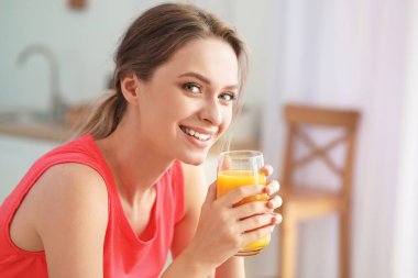 Genç bir kadın mutfakta sağlıklı meyve suyu içiyor. Diyet kavramı