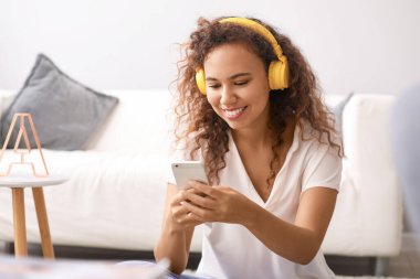 Güzel Afrikalı-Amerikalı kadın evde müzik dinliyor