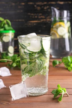 Masada buz küpleri olan bir bardak sağlıklı su.