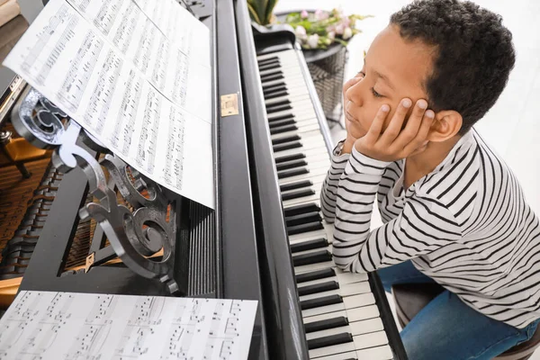 Bored African-American boy at grand piano — Stock Photo, Image