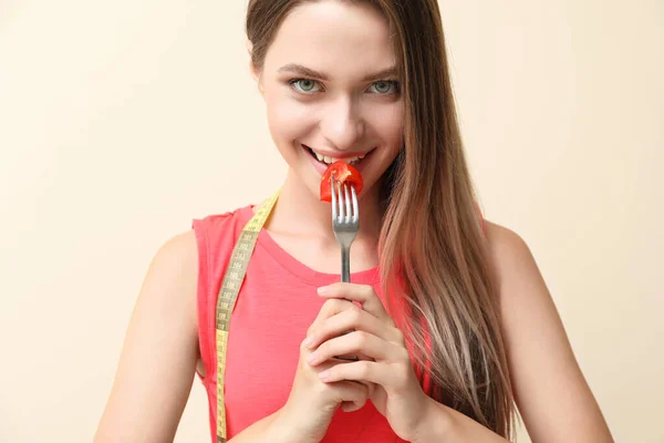 餐叉上有新鲜的西红柿，背景上有测量带子的女人。 饮食概念 — 图库照片